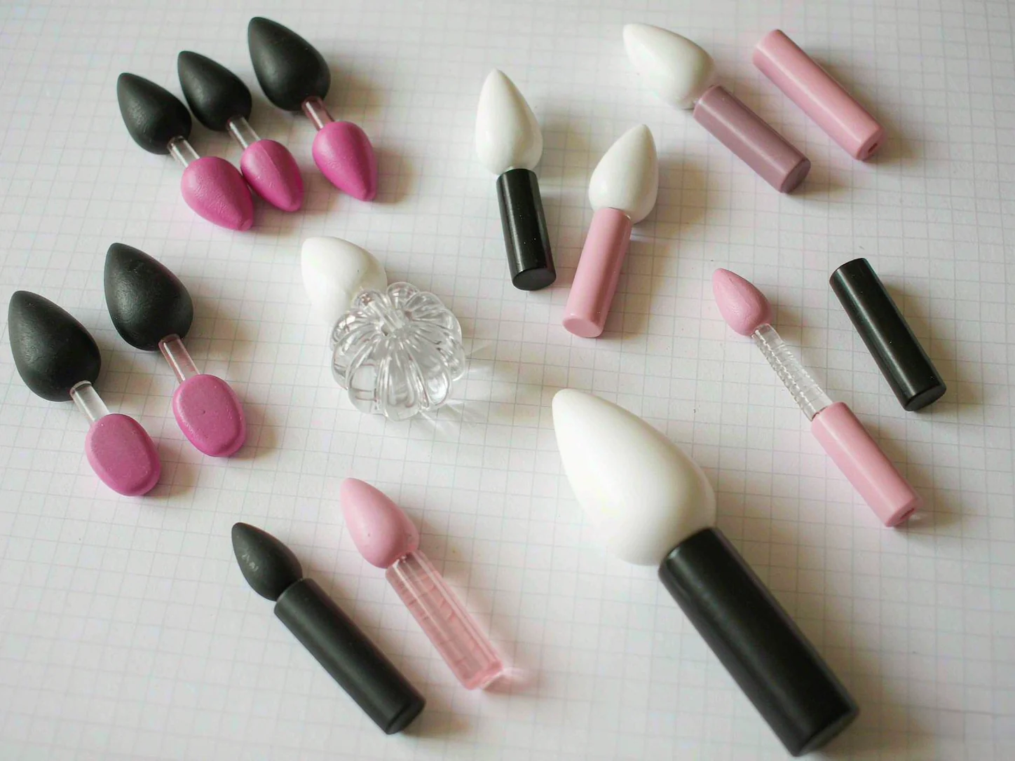 Assorted molded cosmetic applicator components with flocked tips