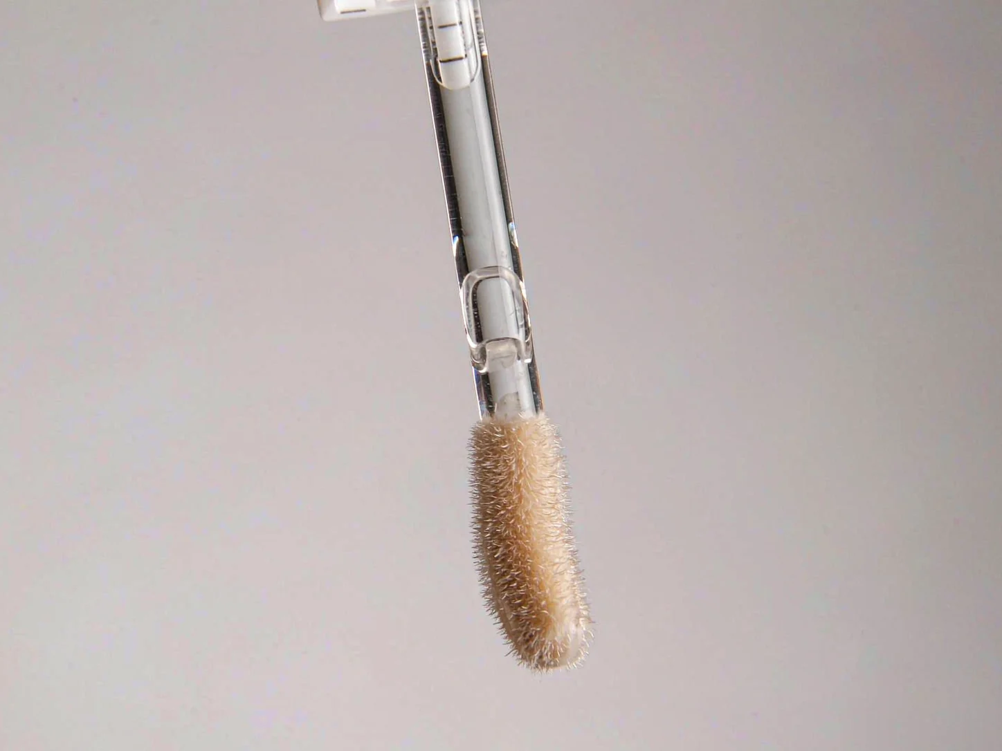 Flocked doe-foot tip on a lip gloss applicator wand