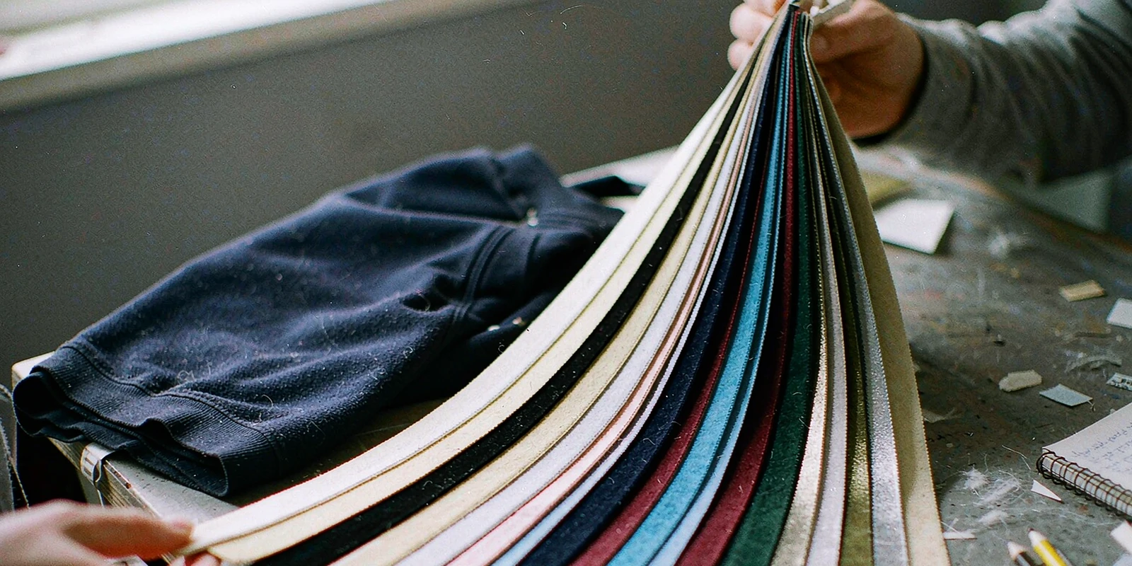 Flocked team colour swatch fan held beside a navy football shirt sleeve Flocked team colour swatch fan held beside a navy football shirt sleeve