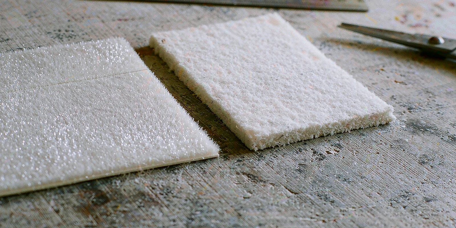 Thin electrostatic flock patch next to a thicker felt patch on a workbench Thin electrostatic flock patch next to a thicker felt patch on a workbench